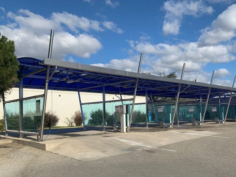 Station de self-lavage à auvent voûté bleu translucide sur mâts inclinés