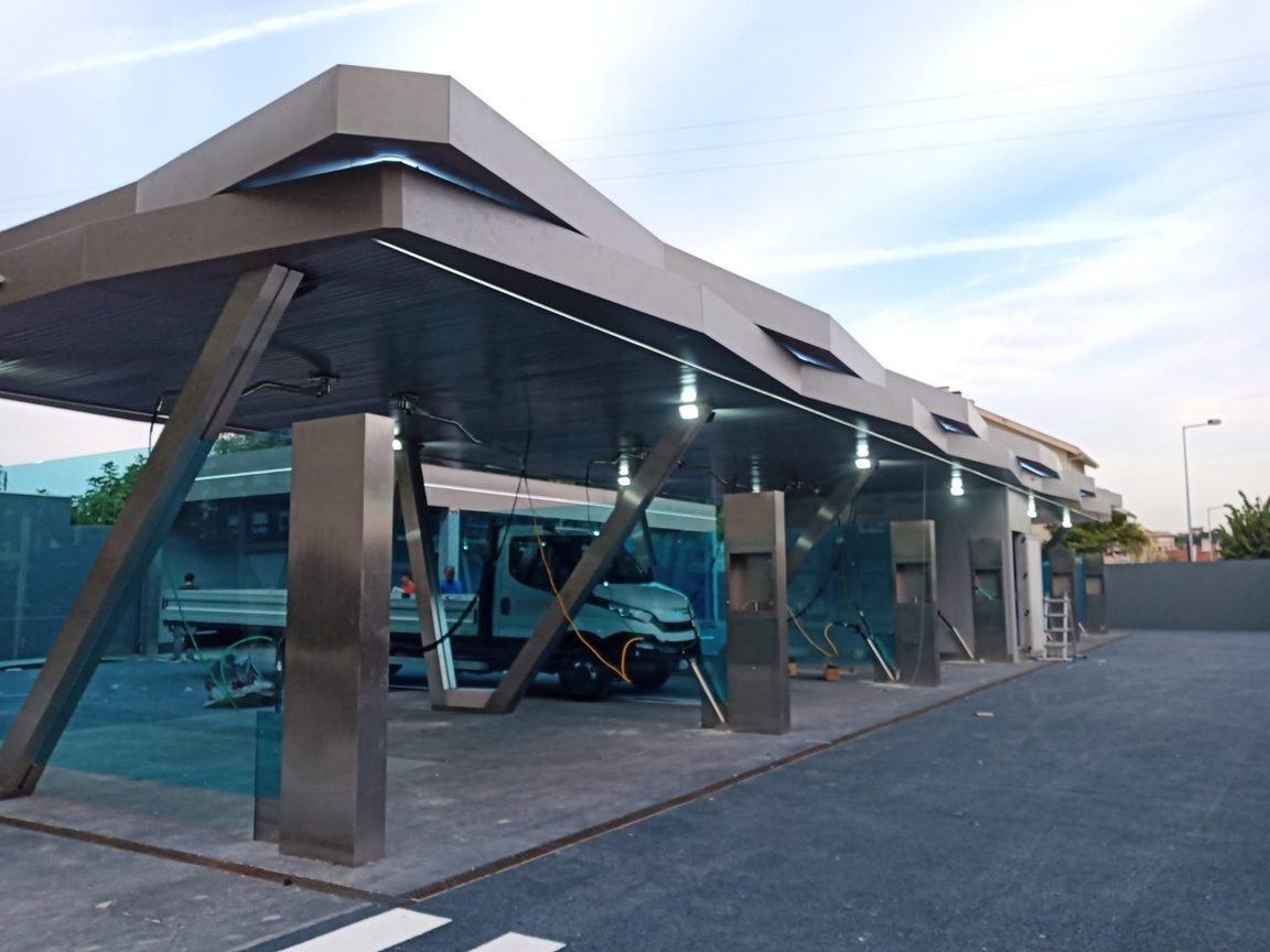 Station de self-lavage à parois de verre teinté et poteaux en acier inoxydable
